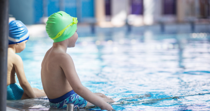 happy children kids group at swimming pool class learning to swim